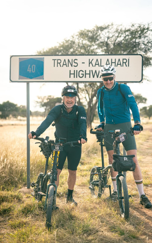 Two men stood by sign