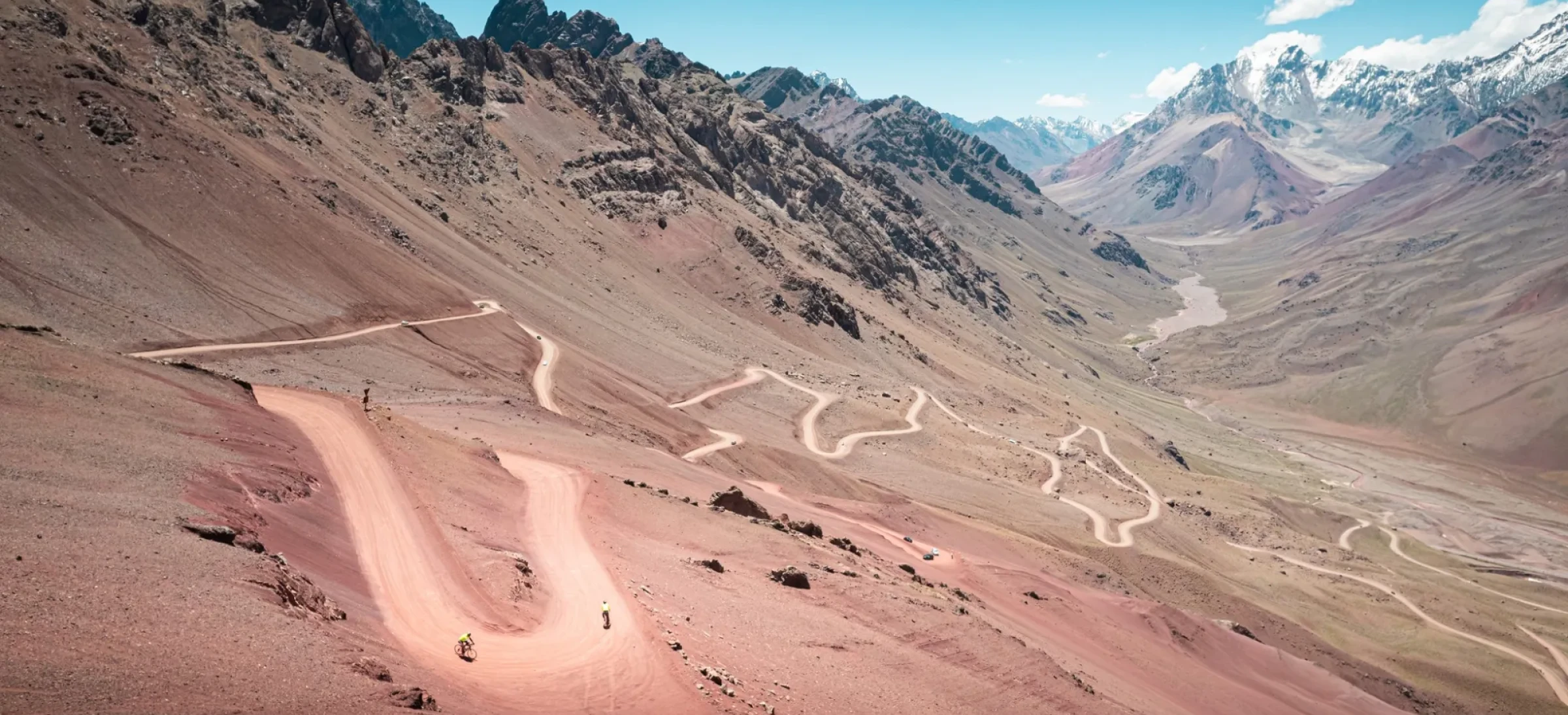 Winding road on dusty terrain with mountains behind
