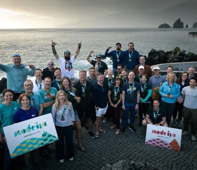 Group of participants smiling and stood infront of water
