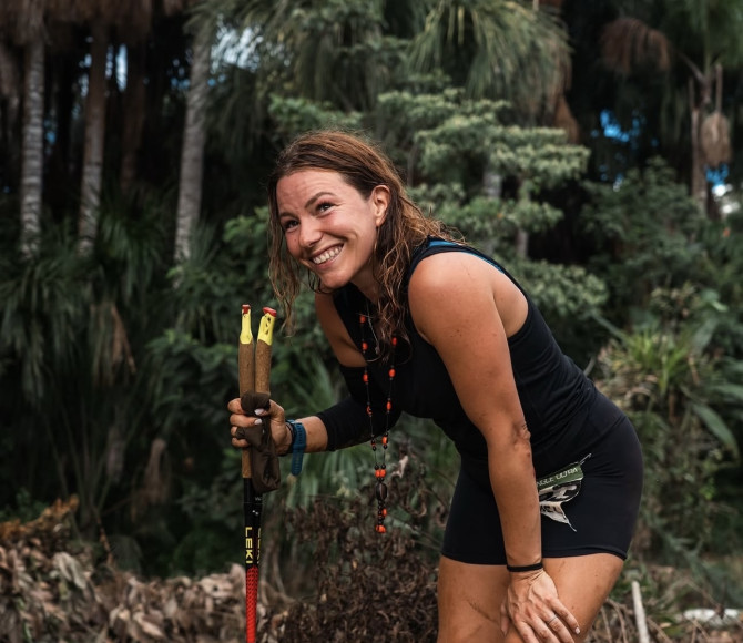Woman stood in a tropical jungle and smiling