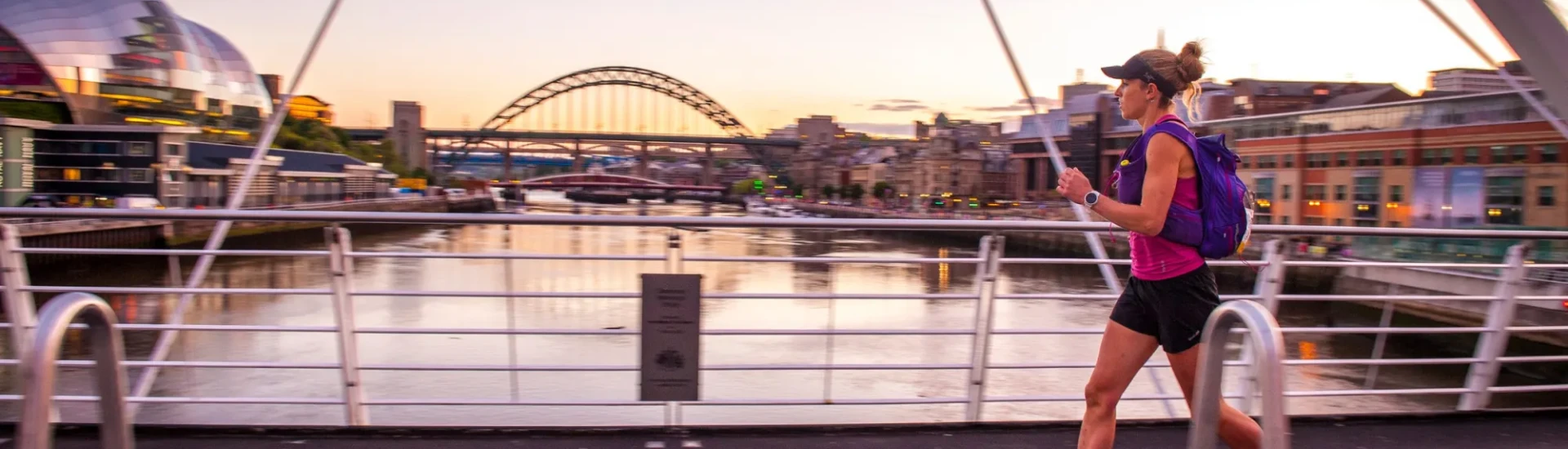 Woman running over bridge in Newcastle