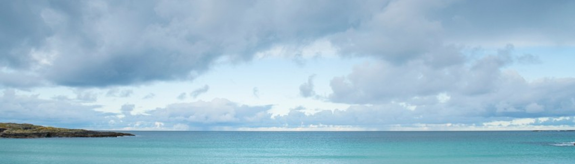 People running on sandy beach with clear sea behind