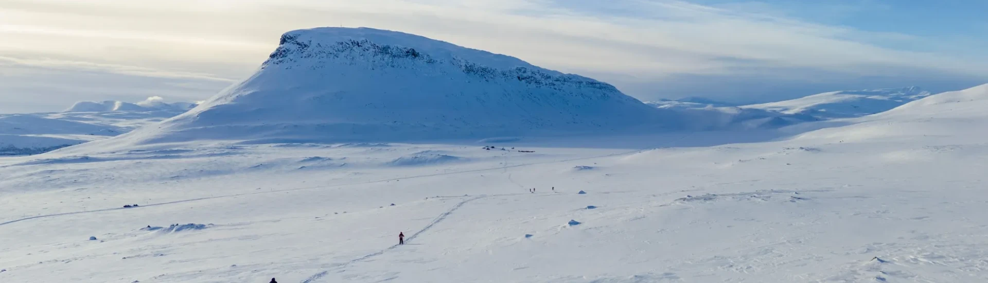 Participants crossing a winter, snowy landscape