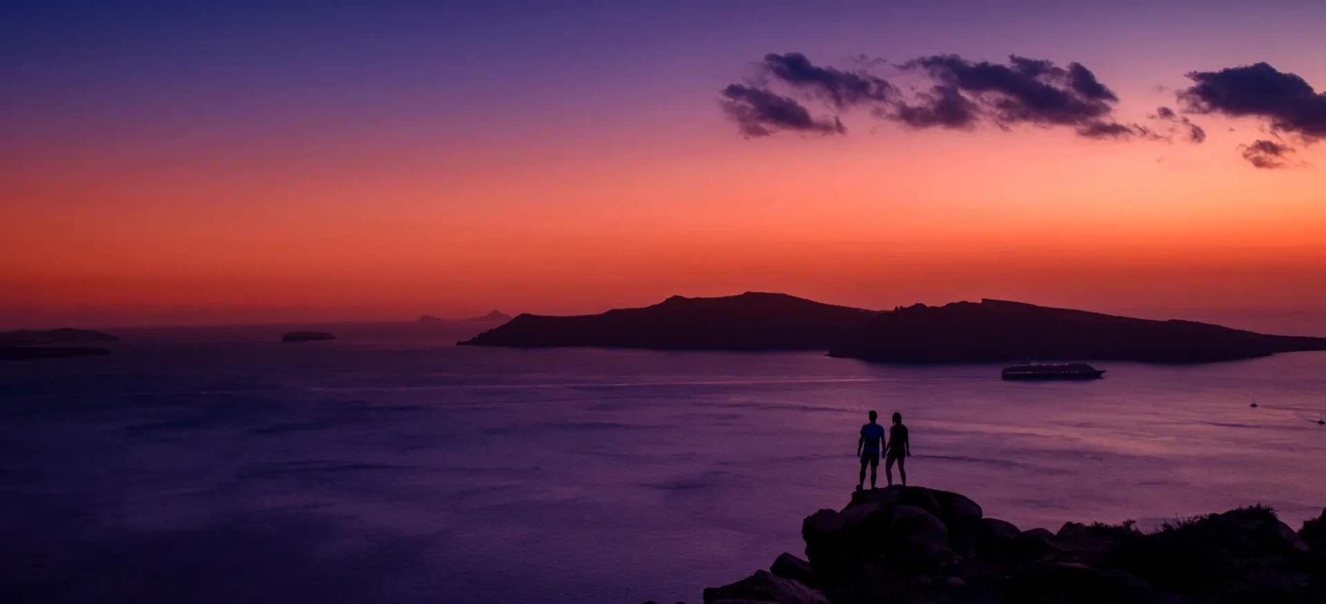 Participants stood on rocks and watching colourful sunset