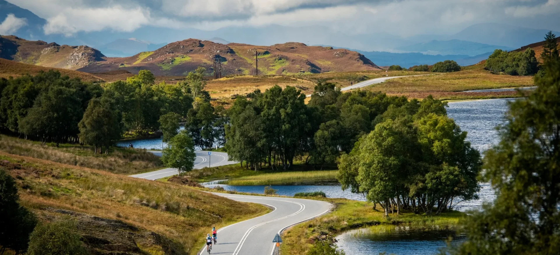 Cyclists riding down winding road