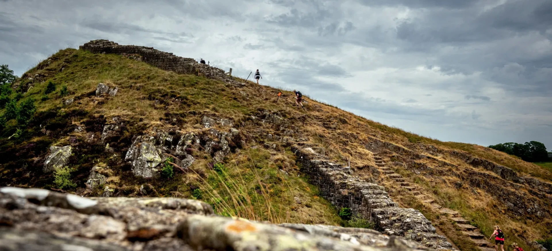 People running up hill along wall
