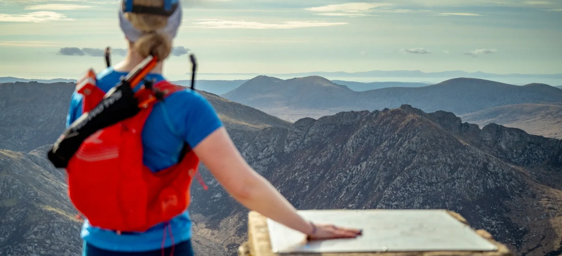 Woman stood at top of mountain looking out at view