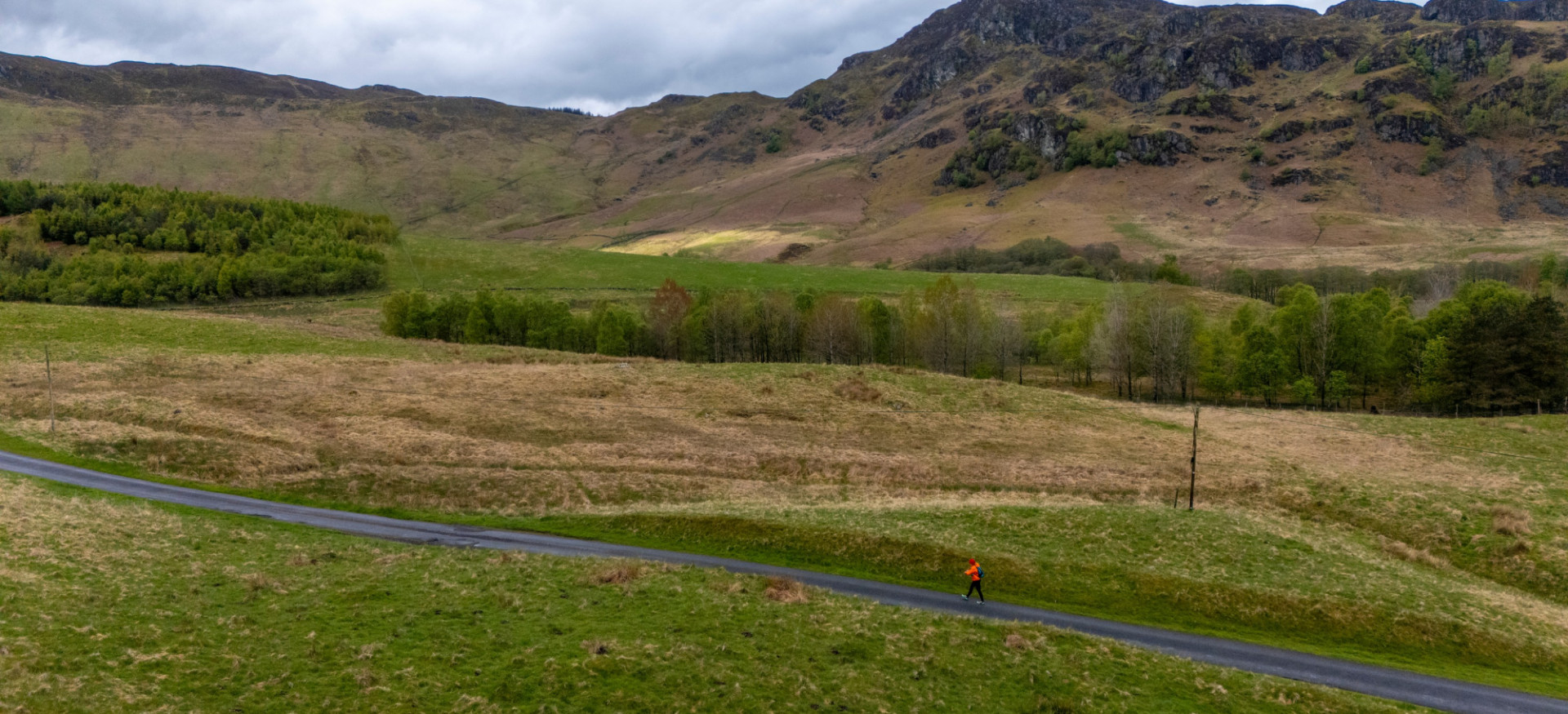 Road with grass either side and mountains in the background