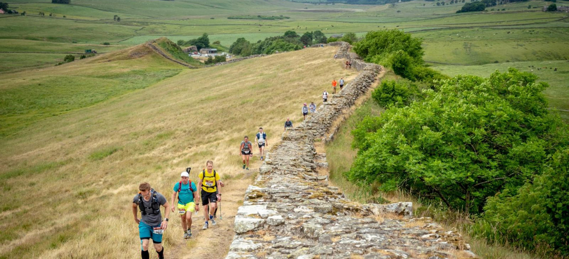People walking beside wall