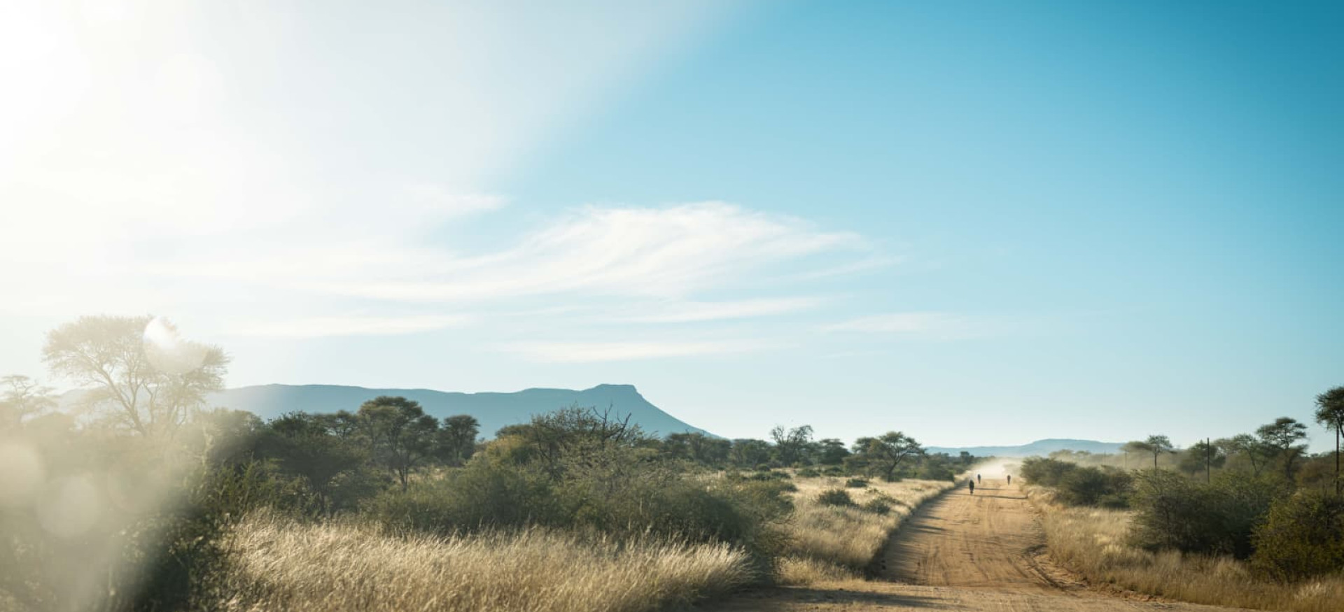 Dust road with cyclists in the distance