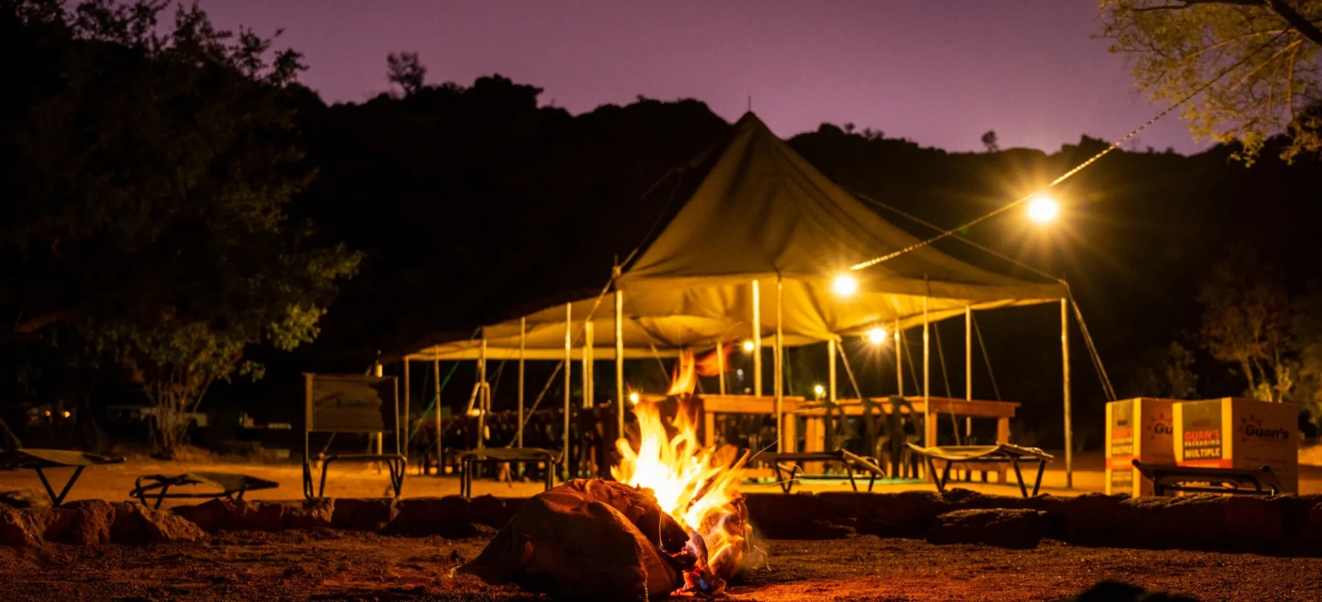 Fire, surrounded by chairs and gazebo behind