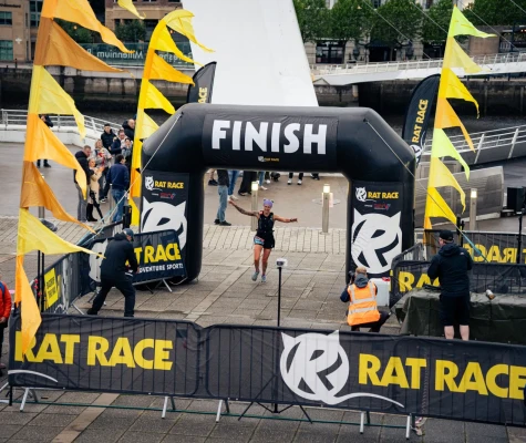 Woman running through finish arch