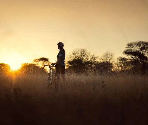 Woman stood on grass with bike