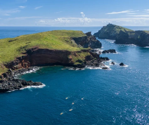 Rocky cliff surrounded by bright, clear water