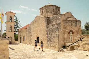 Man and woman running past an old church