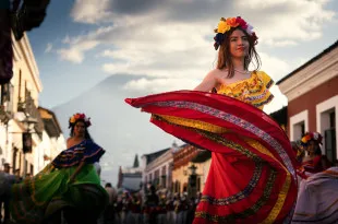 Performers wearing colourful clothing, dancing in the street