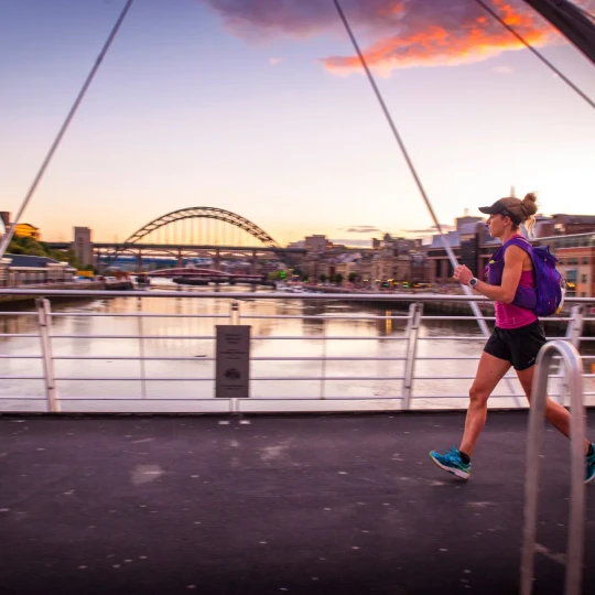 Woman running over bridge in Newcastle