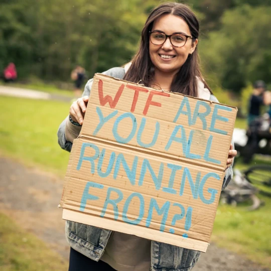 Woman smiling and holding sign