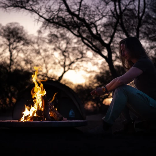 Woman sat by fire at camspite