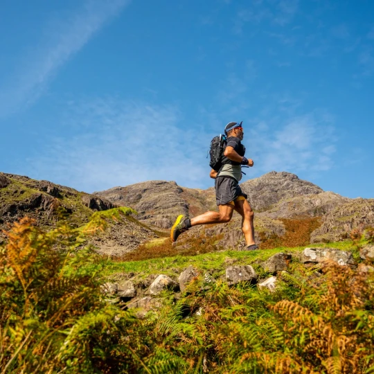 Man running on green, rocky terrain