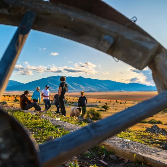 Participants gathered on grassland with mountains in background