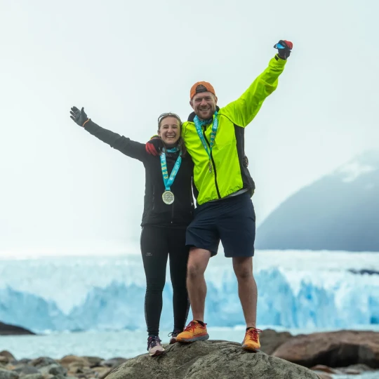 Man and woman stood on rock with medals around their necks