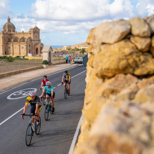 Cyclists riding past grand buildings