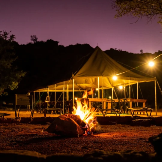 Fire, surrounded by chairs and gazebo behind