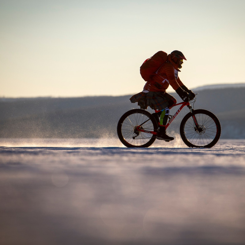 Cyclist riding along snowy and frozen ground