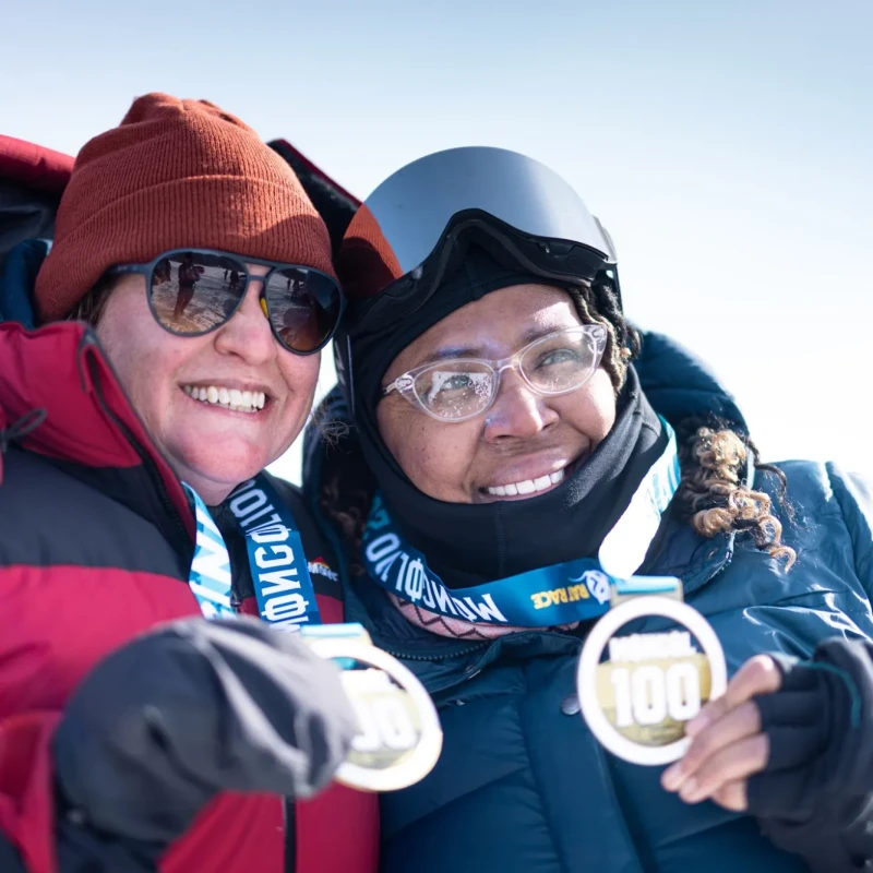 Women smiling and holding medals