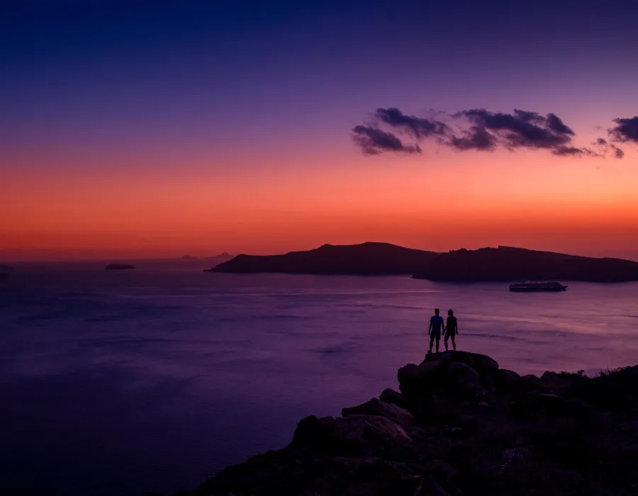 Participants stood on rocks and watching colourful sunset