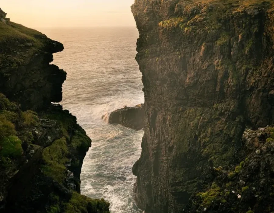 People stood on cliff with colourful sky behind