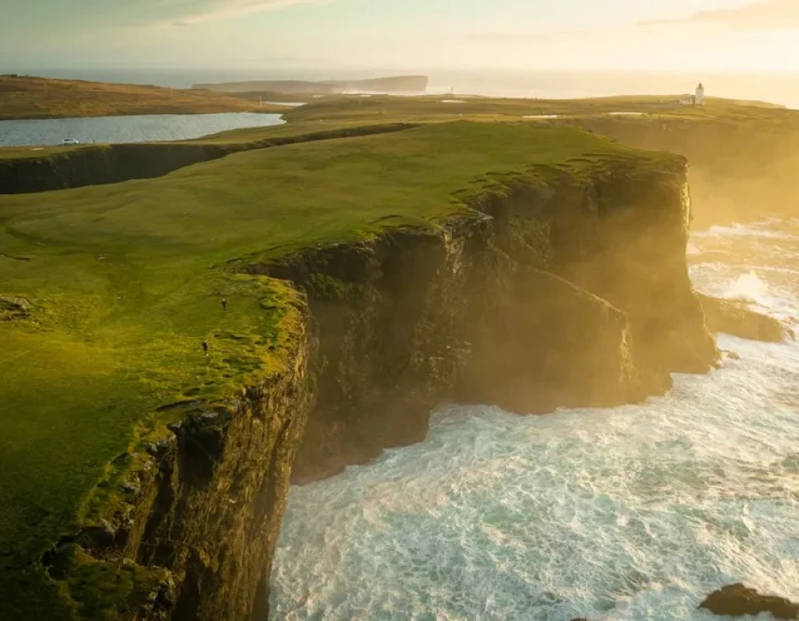 Sunlit green cliffs and water below