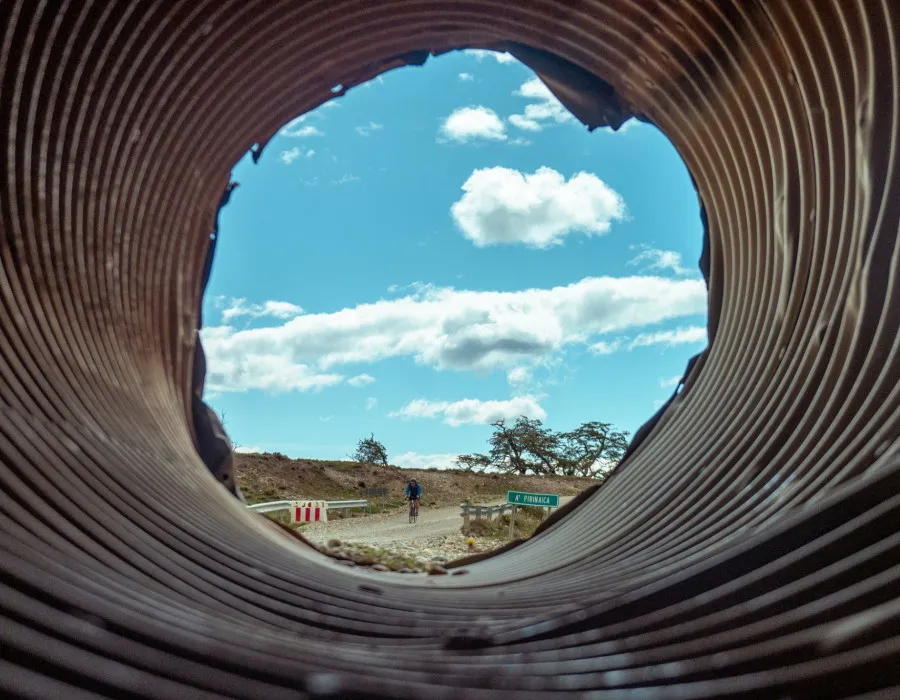 View through pipe of cyclist riding on road