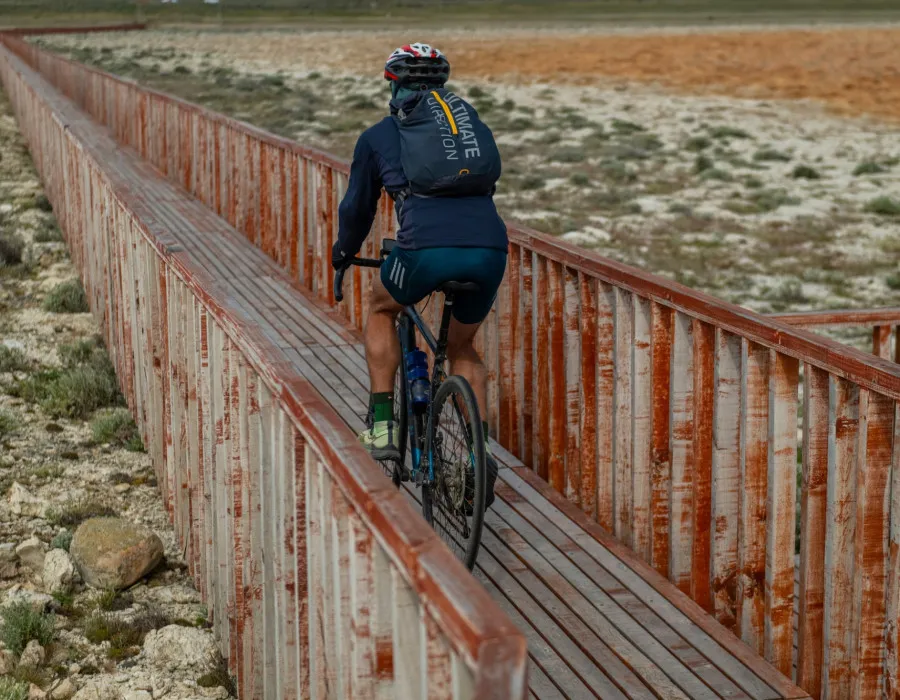 Cyclist riding over narrow wooden path