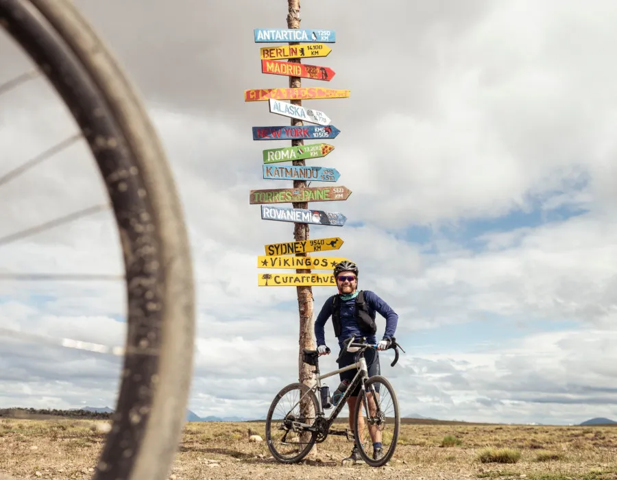 Man stood infront of signs pointing to different places
