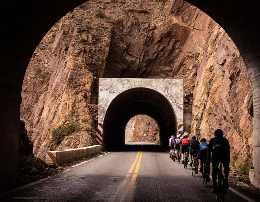 Cyclists riding through tunnel in mountain