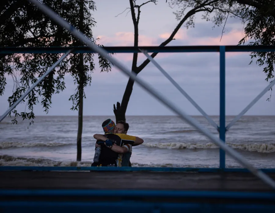 Participants hugging on a beach