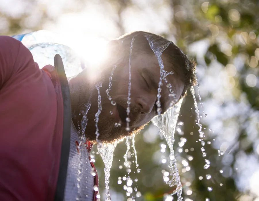 Man pouring water over his head