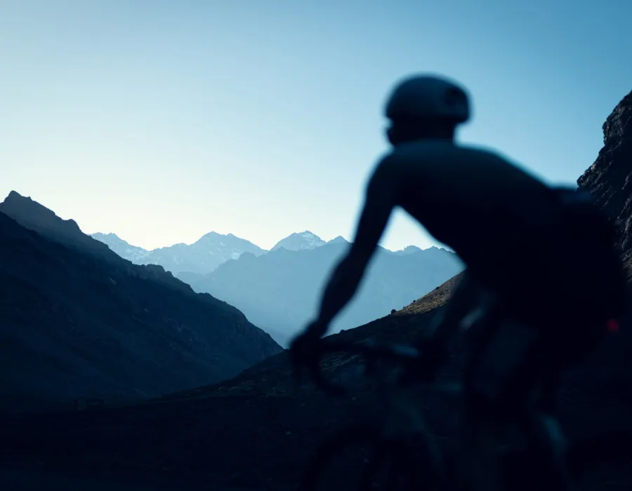 Silhouette of cyclist and bike looking at mountains