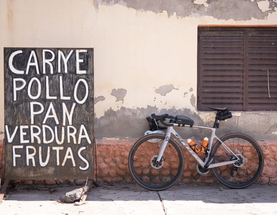 Bike stood against building and next to sign