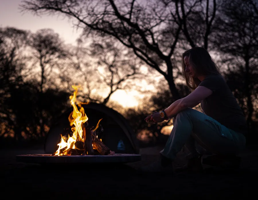 Woman sat by fire at camspite