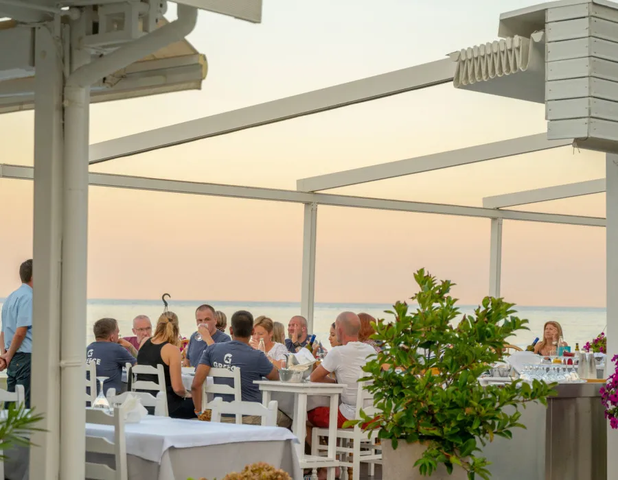 Participants having a meal in a restaurant at sunset