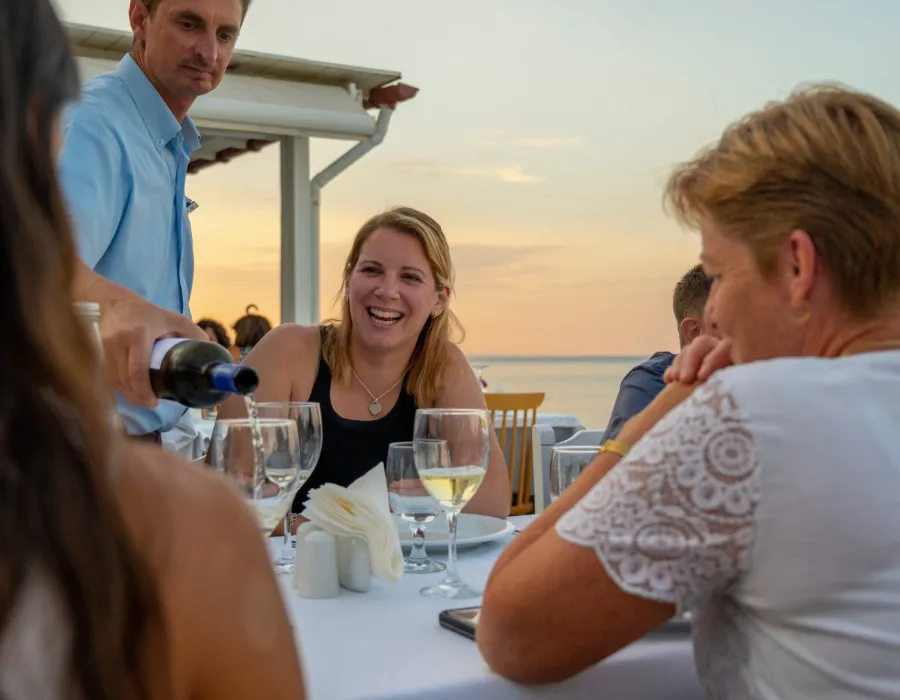 Participants laughing and having  meal at sunset