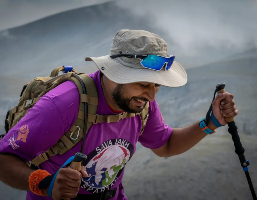 Man using trekking poles and hiking up rocky mountain