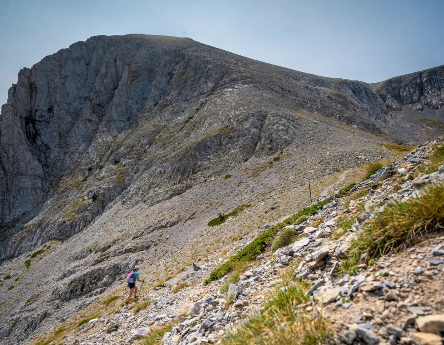 Woman walking up mountainous, rocky terrain