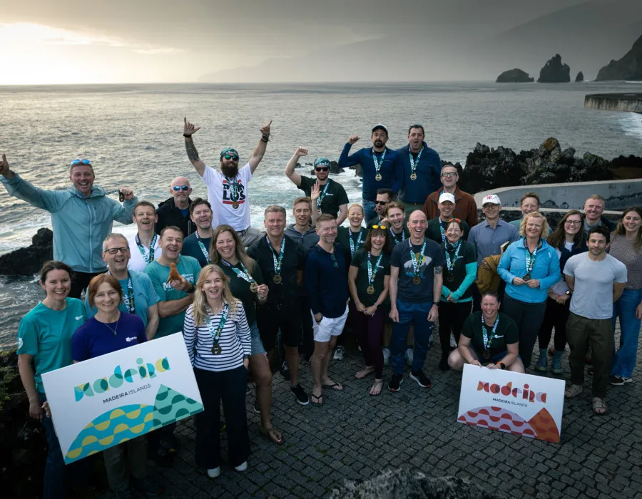 Group of participants smiling and stood infront of water