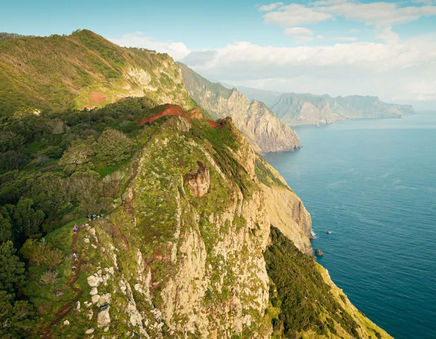 Green mountains next to bright, clear sea