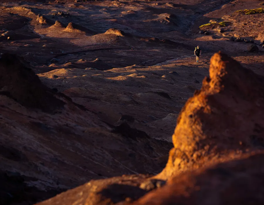 Participant walking over rocky, sunlit terrain