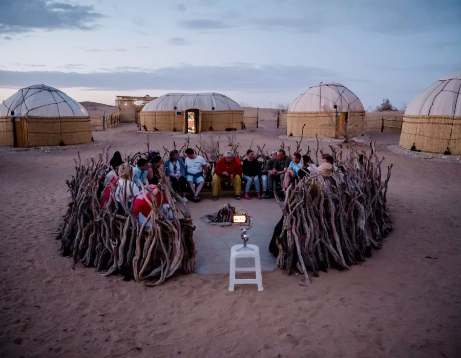 Participants gathered round and yurts in background